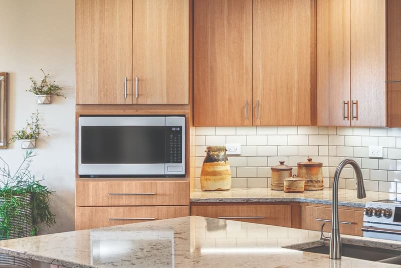 Built-in microwave cabinet seamlessly integrated into modern kitchen cabinetry.