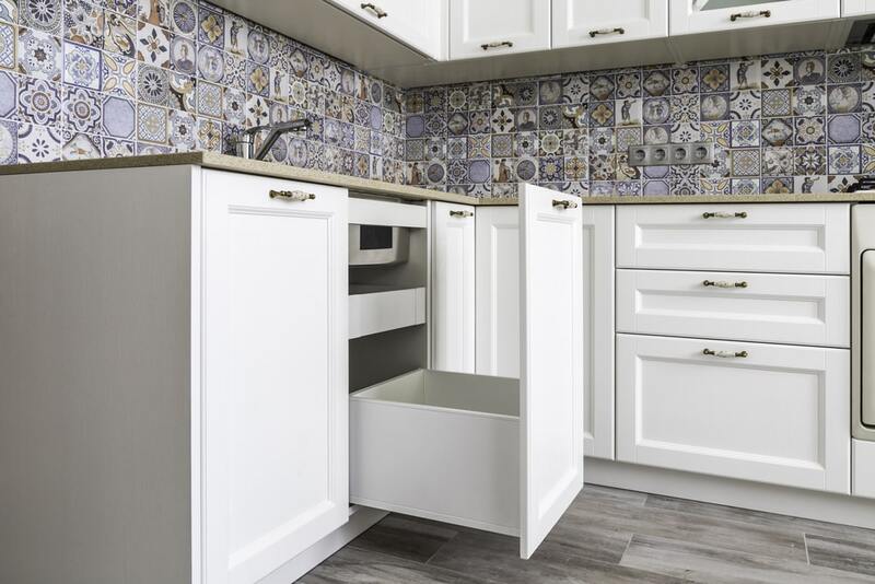 Interior view of a sink base cabinet showing dummy panels and adjustable shelves