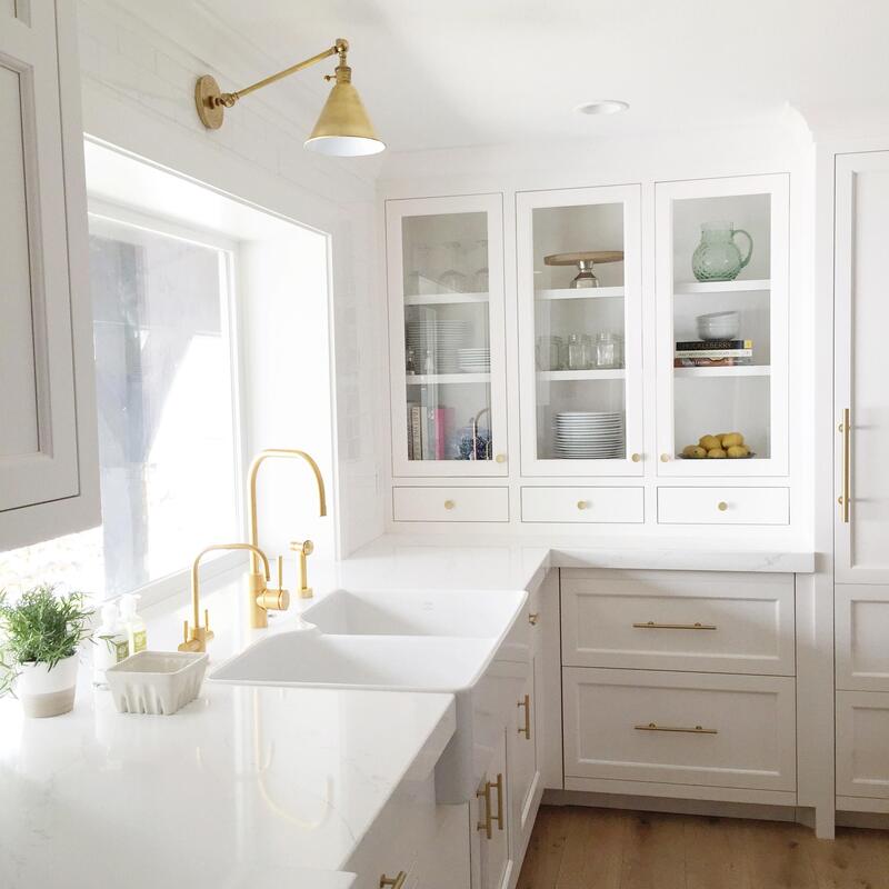 Warm Kitchen Cabinet Colors: Modern kitchen featuring warm white cabinets, gold hardware, and wood countertops