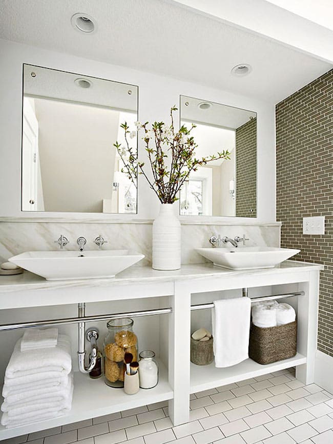 Bathroom cabinet with open shelves, showcasing folded towels and decorative plants in a modern bathroom