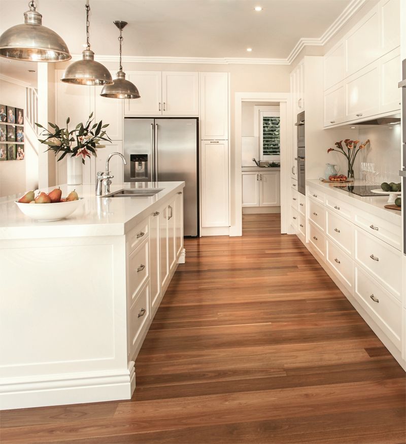 Compact kitchen featuring warm white cabinets paired with natural wood floor