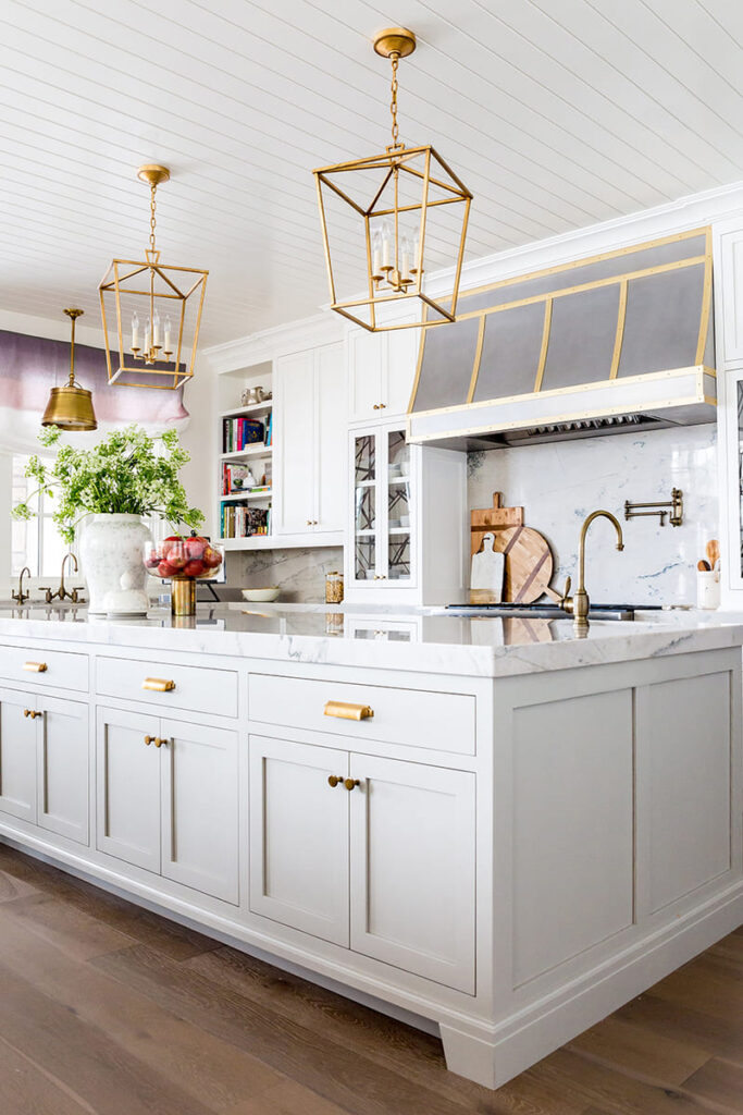 Contemporary kitchen featuring painted kitchen cabinets in soft white with gold hardware