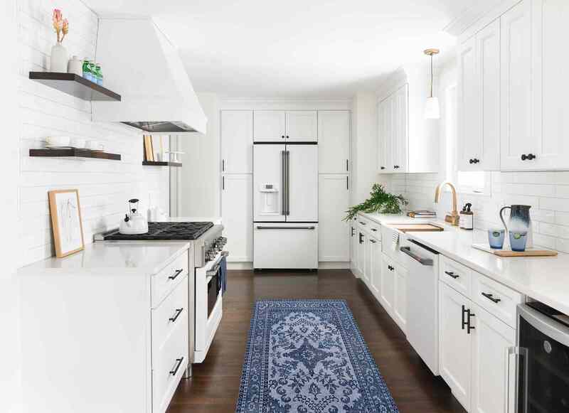 Minimalist kitchen featuring matte white painted cabinets and black hardware