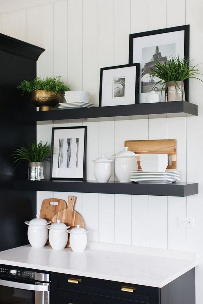 Modern kitchen featuring floating shelves styled with white dishes and greenery