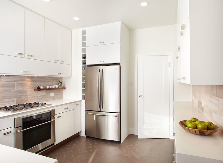 Modern kitchen featuring warm white frameless cabinets, stainless steel appliances, and a glass backsplash