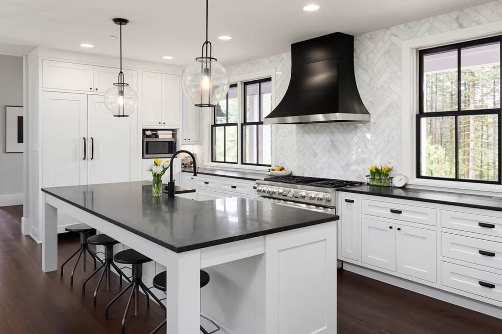 Modern kitchen with white painted cabinets, black countertops, and black hardware