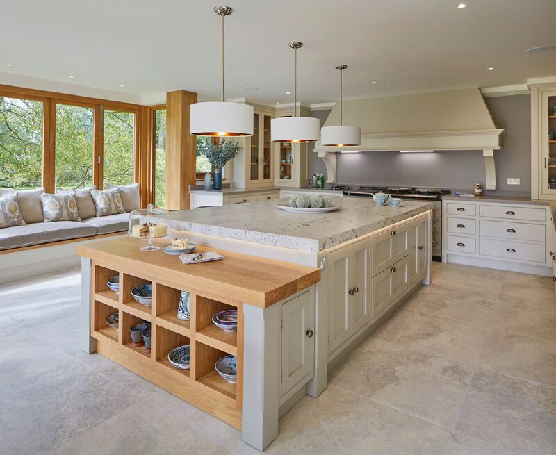 Multi-level kitchen island with a prep surface, raised dining area, and built-in storage in a bright, family-friendly kitchen