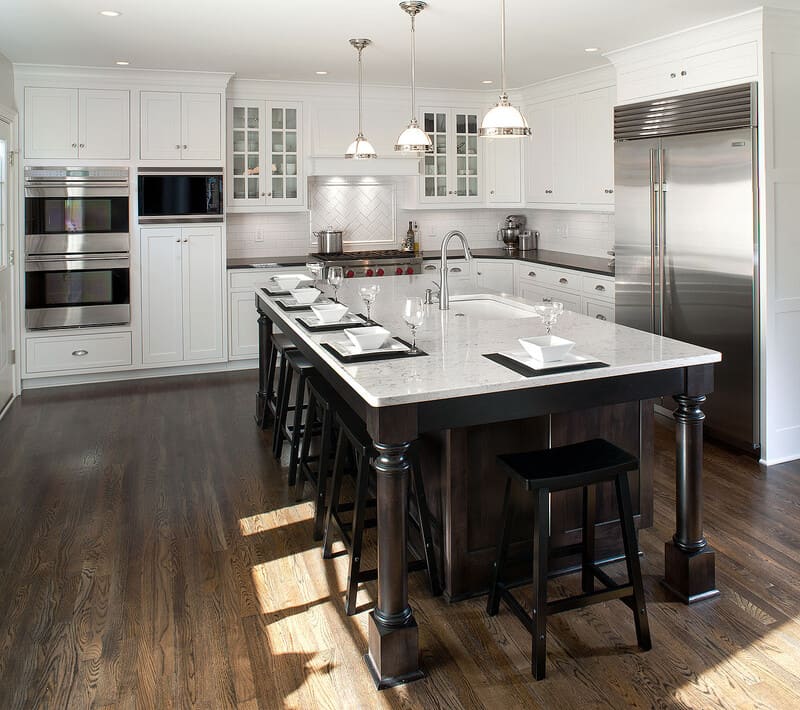 Transitional kitchen with warm white painted cabinets, wood countertops, and brass hardware