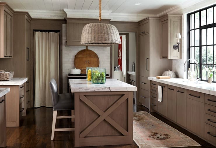 Scandinavian kitchen with light brown painted cabinets, white countertops, and black hardware