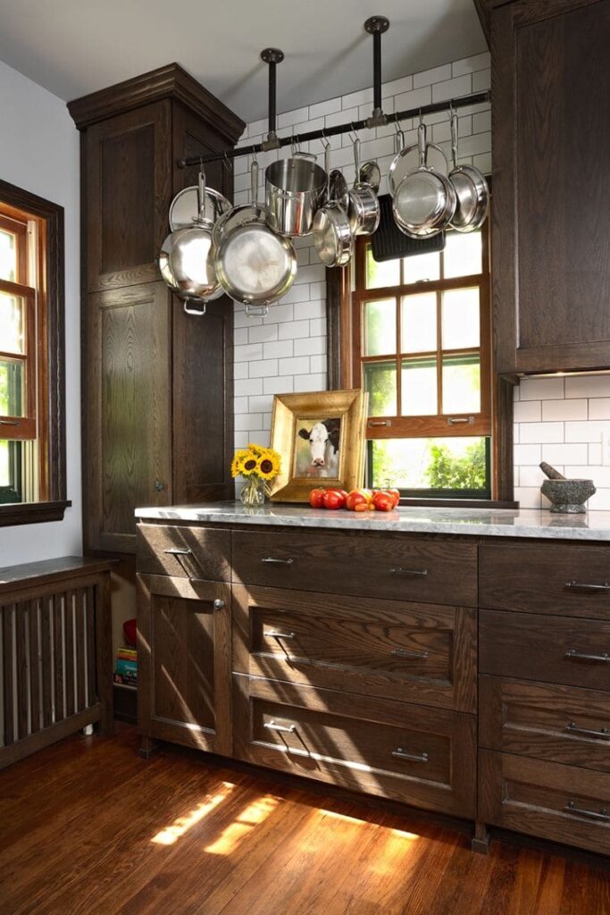 Kitchen featuring dark brown cabinets with brass hardware and marble finishes for a modern luxe aesthetic