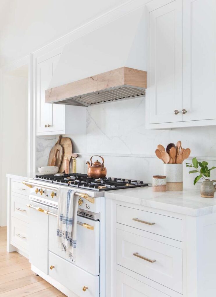 A contemporary kitchen showcasing stainless steel pulls on lower cabinets and smaller chrome knobs on upper cabinets for a cohesive, functional look