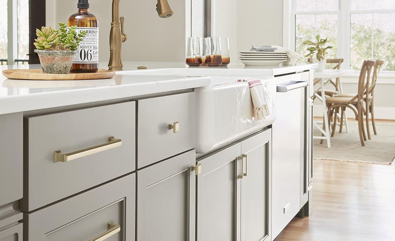 Close-up of a modern kitchen featuring cabinet knobs and pulls of various sizes, perfectly proportioned for each door and drawer