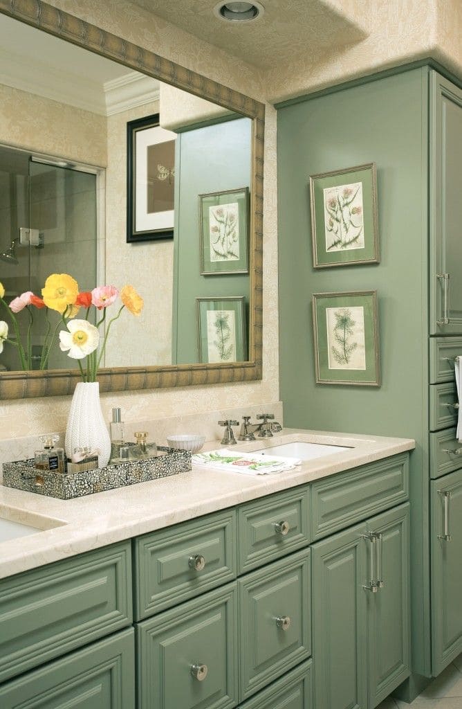 A bathroom with sage green painted cabinets