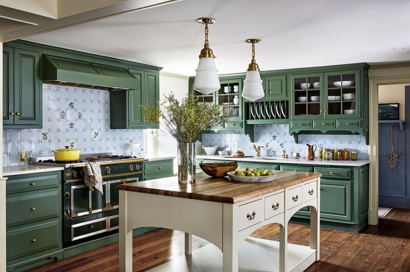 A luxurious kitchen featuring green painted cabinets with gold hardware