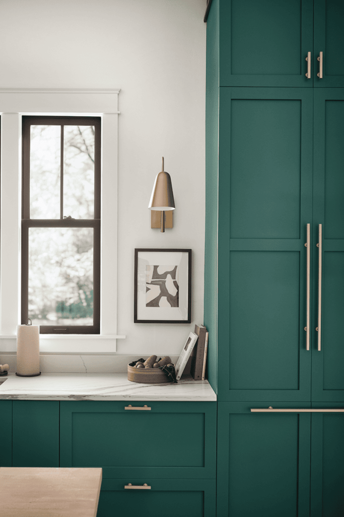 A luxury kitchen showcasing emerald green painted cabinets with marble countertops and chrome accents