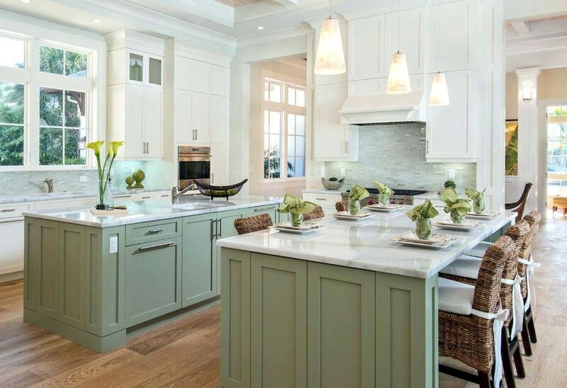 A modern kitchen featuring sage green painted cabinets paired with white countertops, showcasing timeless elegance