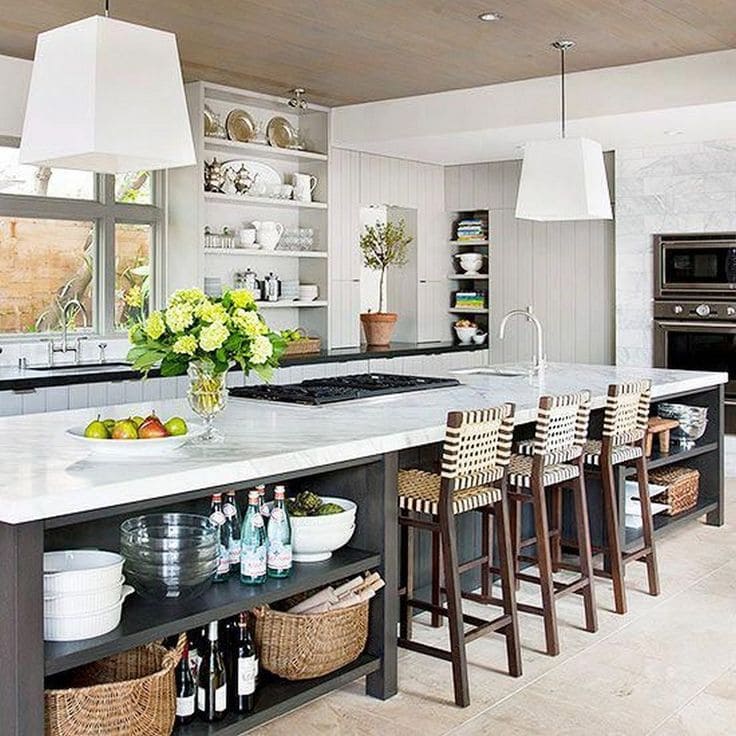 Open-plan kitchen featuring a large kitchen island with built-in seating and storage