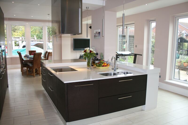 Large kitchen island with integrated sink and stove top, designed for a spacious open-plan home