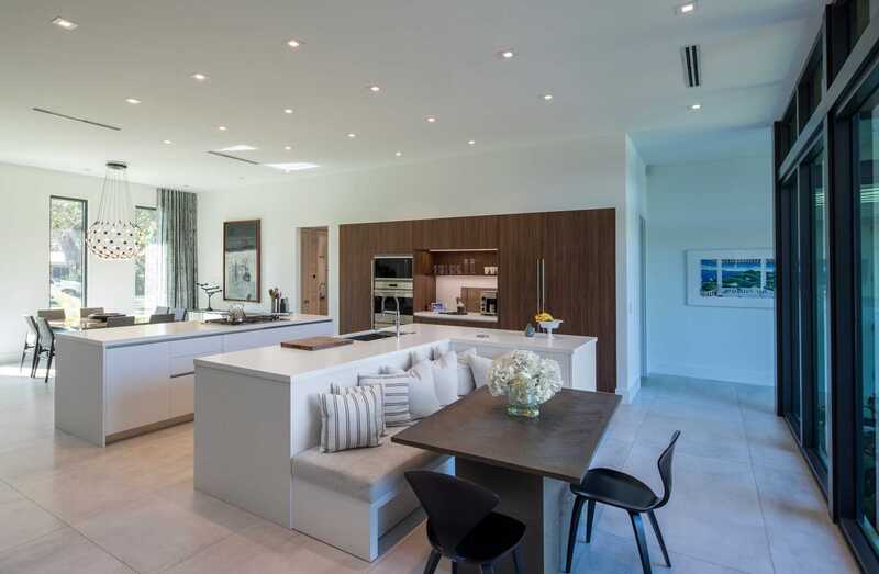 A modern L shaped kitchen with island featuring ample seating, and a well-lit dining space perfect for entertaining