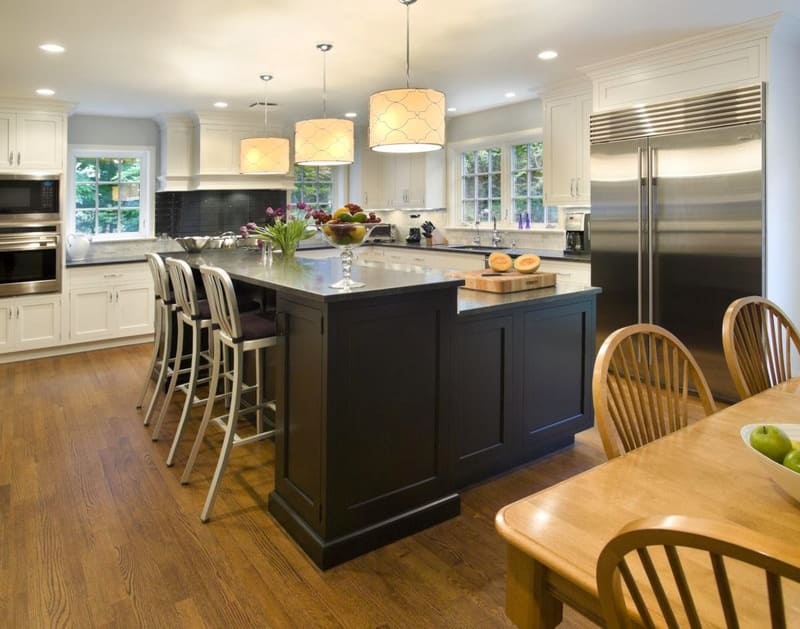 An inviting dining island in an L shaped kitchen, featuring stylish bar stools