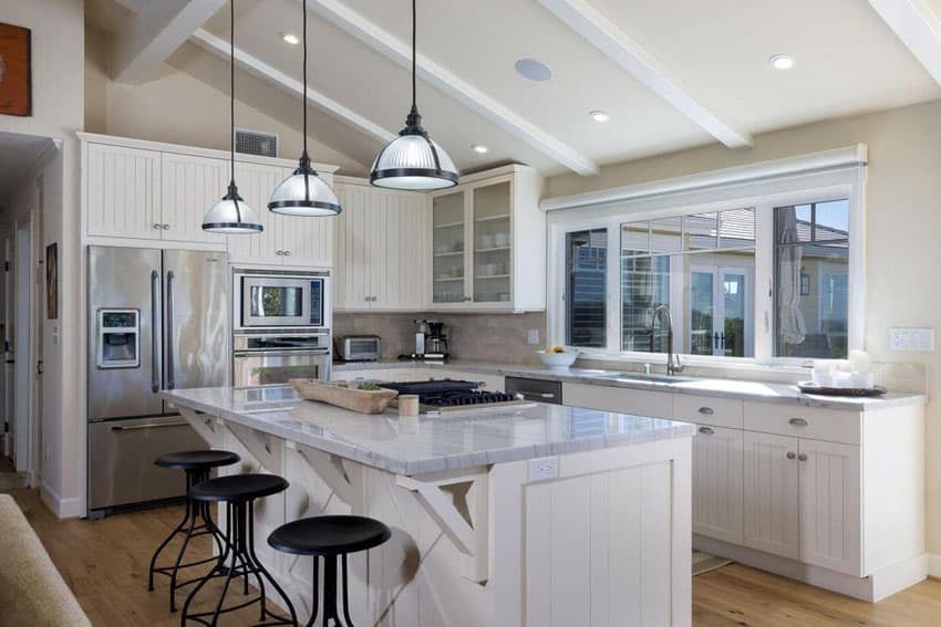 An L shaped kitchen with island featuring a cooktop, ample counter space, and stylish bar seating for casual dining and entertainment