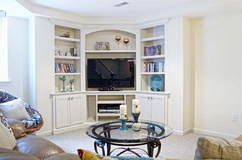 A compact corner media wall cabinet with adjustable shelves, maximizing storage in a small living space