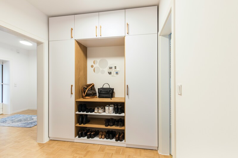 A custom-built shoe cabinet with sleek, adjustable shelving and a contemporary design by Casta.