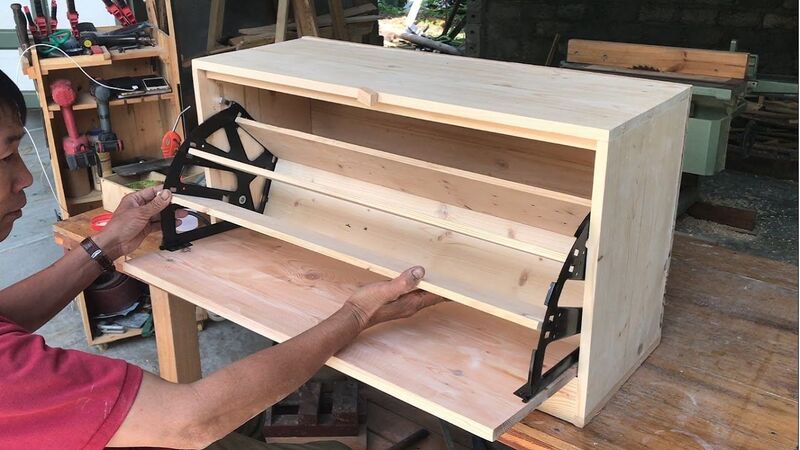 A contractor precisely measuring all three dimensions—width, height, and depth—to fit a shoe cabinet into a modern living space