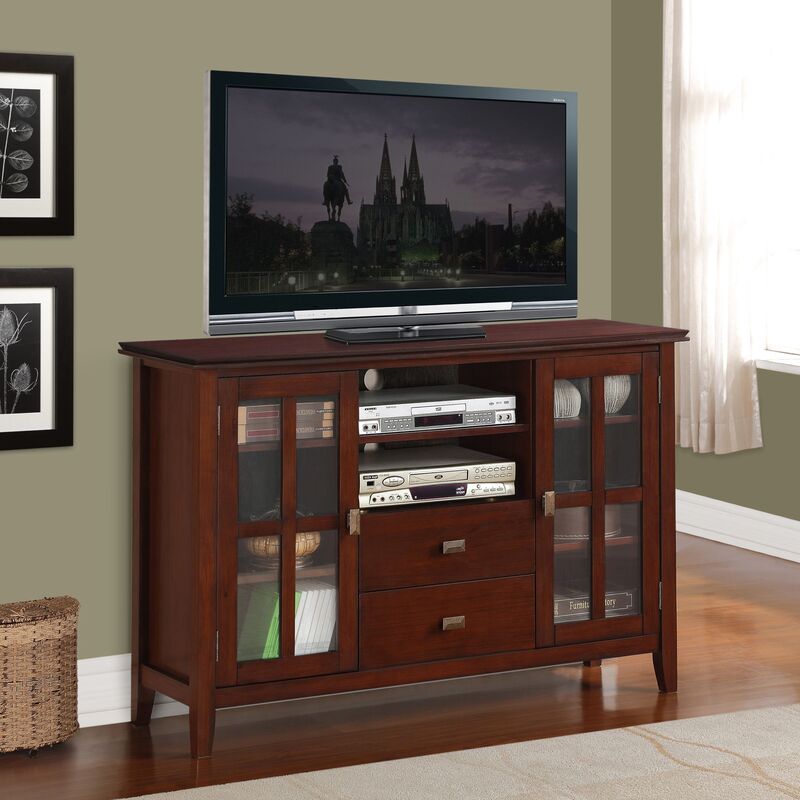 A bold tall media cabinet with a dark wood finish and brushed metal accents in a high-end home theater