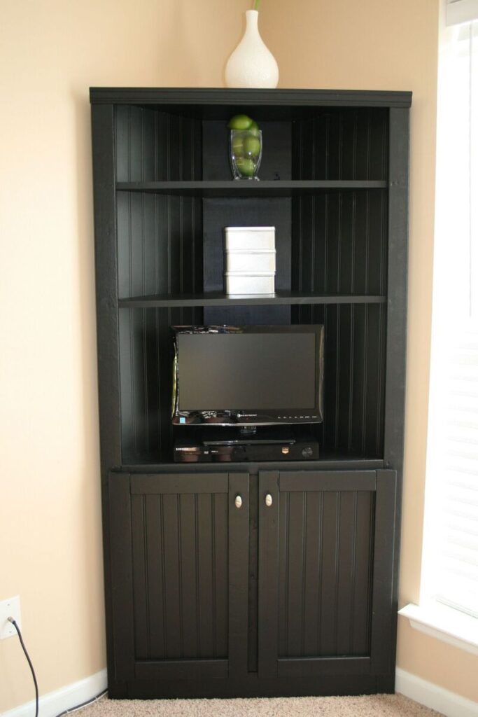 A tall media cabinet with a vertical design and integrated shelves, perfect for organizing a small urban apartment