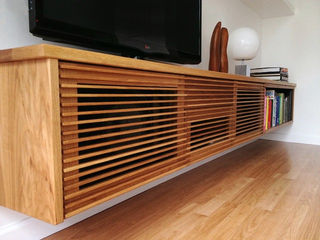 A floating light wood media cabinet mounted on a wall, ideal for a minimalist living room