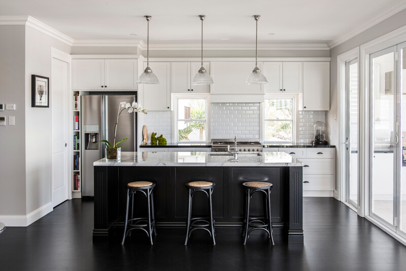 A well-designed kitchen showcasing the ideal distance between a functional island with seating and surrounding cabinets, ensuring smooth traffic flow