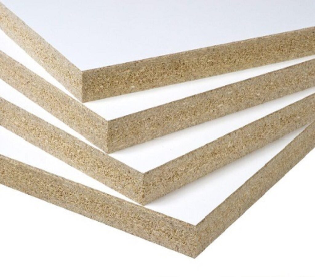 Sheets of melamine-faced particleboard stacked and ready for cutting in a cabinet door factory