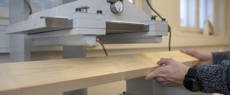 Laboratory technician performing moisture resistance testing on wood panels for private label furniture production