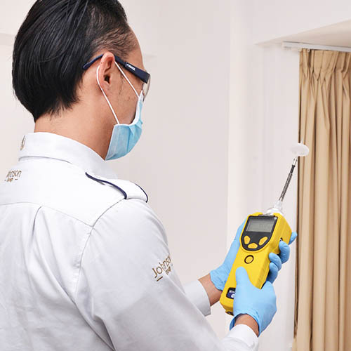 Quality control specialist measuring VOC levels in a cabinet panel in Vietnam
