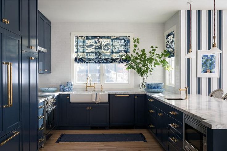Navy kitchen cabinet colors accented with brass for a bold statement