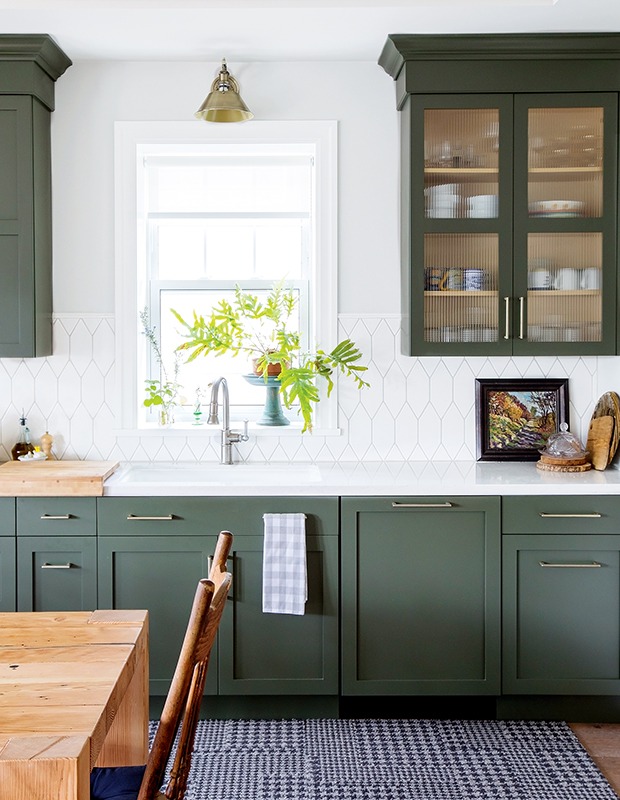 Green and white kitchen cabinets with natural tones