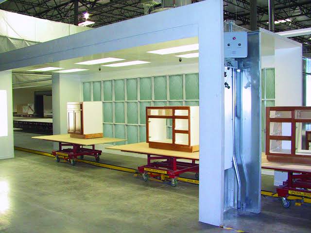Controlled spray booth finishing during the kitchen cabinet construction process