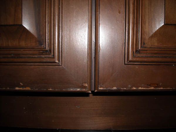 Close-up of a cabinet door surface being checked for finish defects