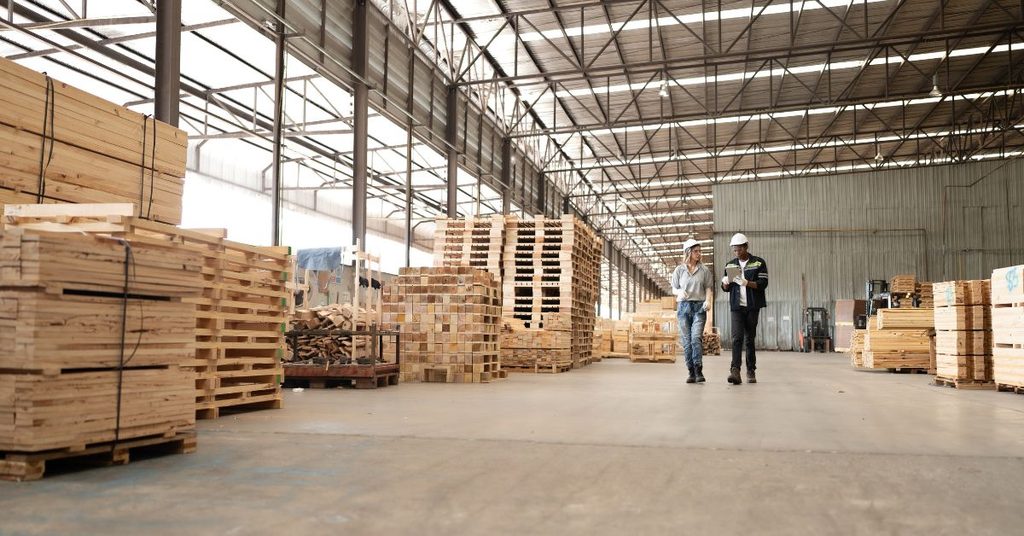 Stack of wood panels being inspected at a factory warehouse