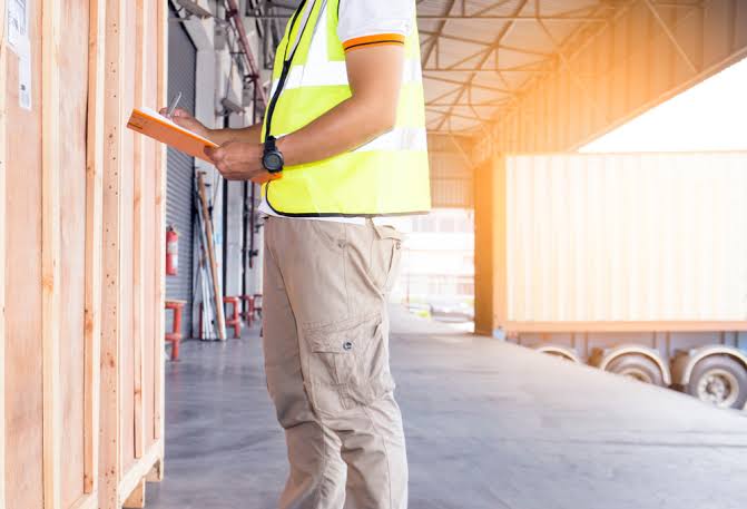 Inspector pulling random cabinet units from a pallet for sampling