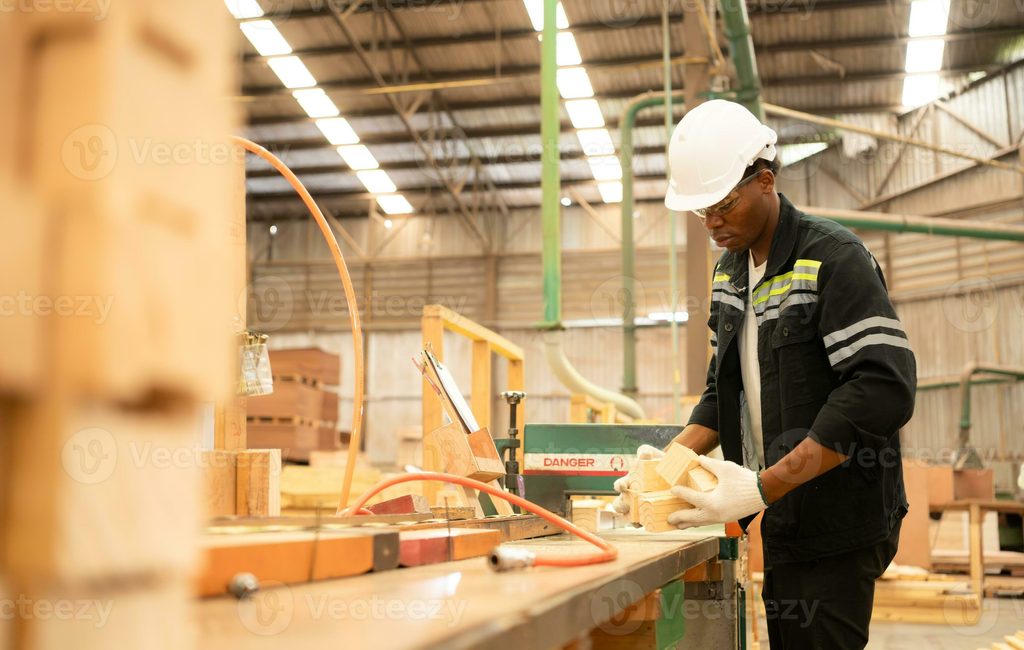 Factory worker feeding wood panels into a cutting machine