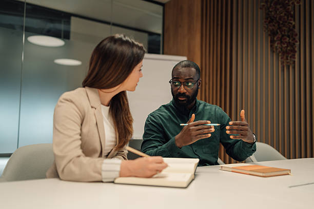 Two people reviewing a quote and a forecast at a meeting table