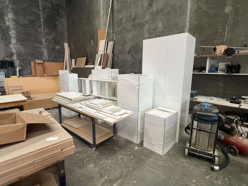 Labeled cabinet cartons stacked by unit at a job site