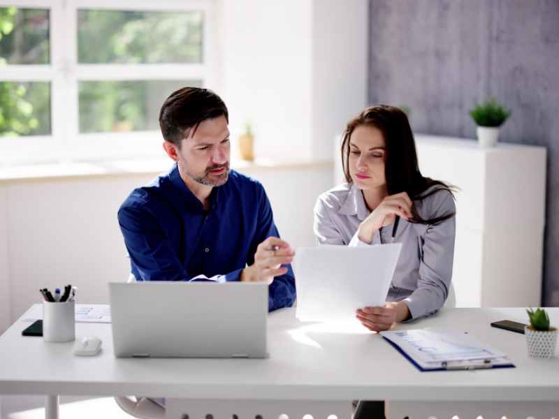 Property manager comparing three supplier proposals on a desk