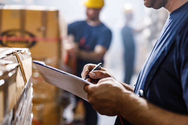 Warehouse worker checking cabinet boxes against a shipment order